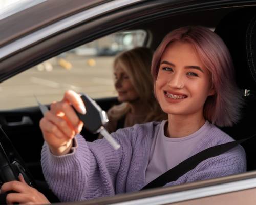 Une jeune conductrice souriante montre les clés de sa voiture depuis le siège conducteur